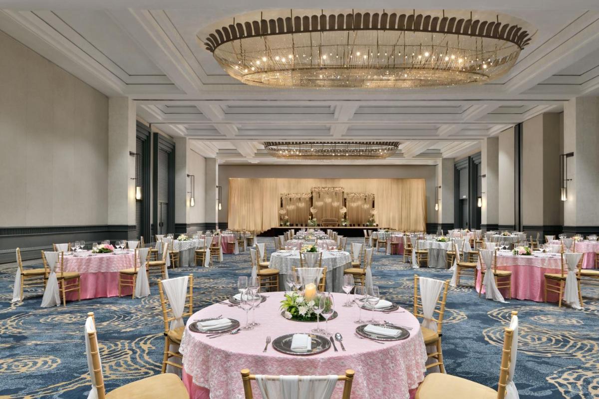 a banquet hall with tables and chairs and a chandelier at The Westin Mumbai Powai Lake in Mumbai