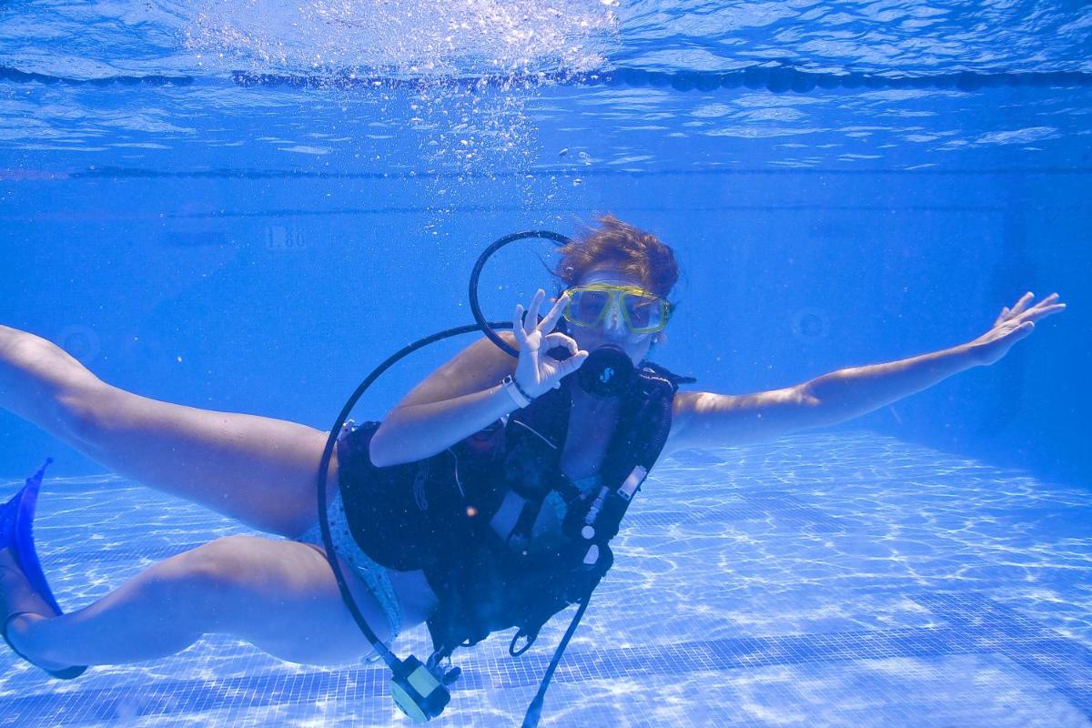 una mujer nadando en el agua con una cámara en JS Cape Colom - Adults Only, en Portocolom