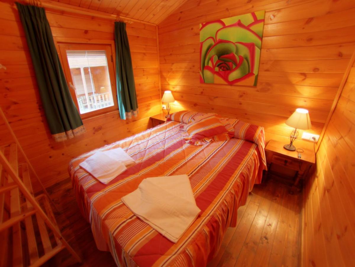 Un dormitorio con una cama en una cabaña de madera. en Balneario San Andres, en Canena 50 fotos más