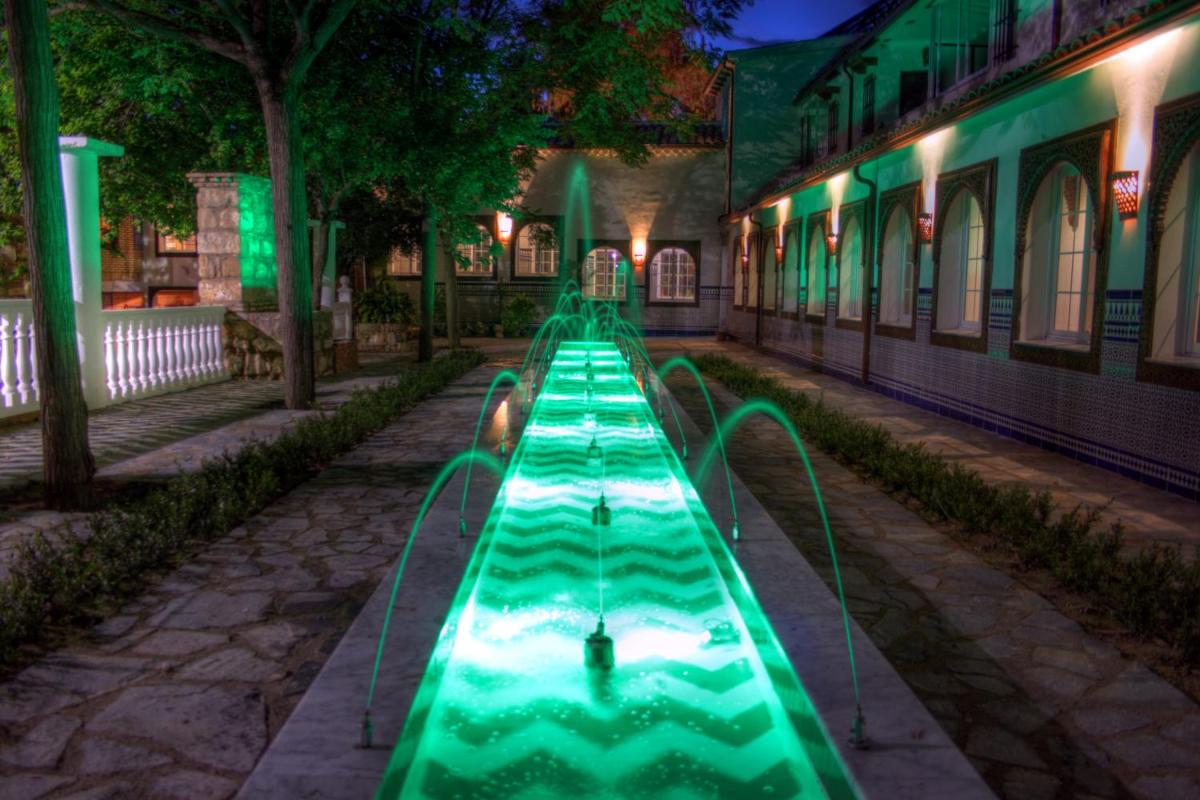 un tobogán de agua verde en un parque por la noche en Balneario San Andres, en Canena