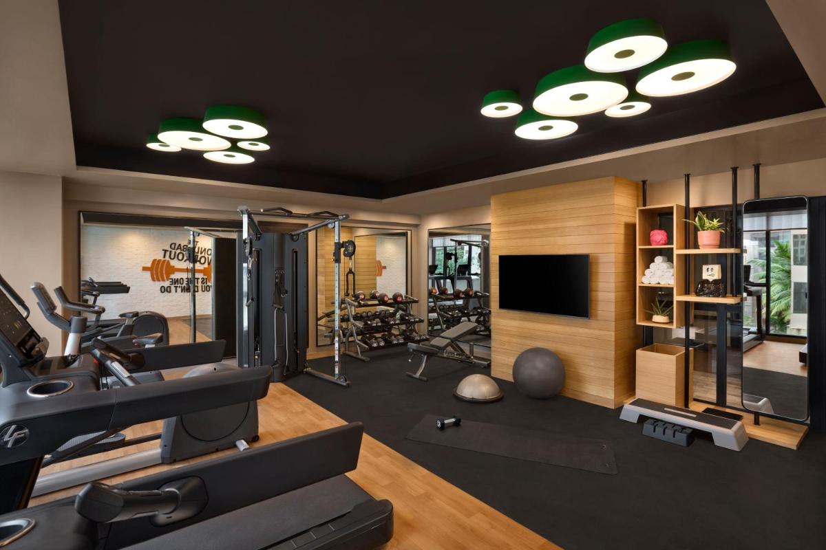 a room with a gym with tread machines and a television at Moxy Mumbai Andheri West in Mumbai