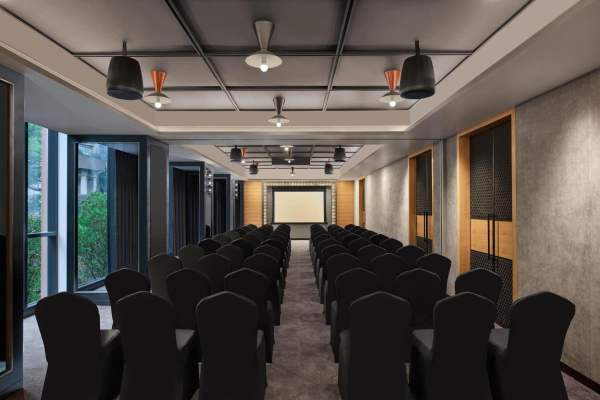 a conference room with black chairs and a screen at Moxy Mumbai Andheri West in Mumbai +39 photos