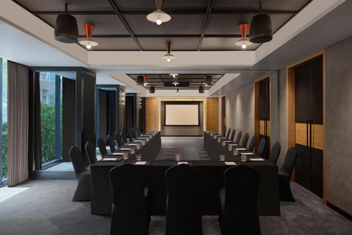 a conference room with a long table and chairs at Moxy Mumbai Andheri West in Mumbai