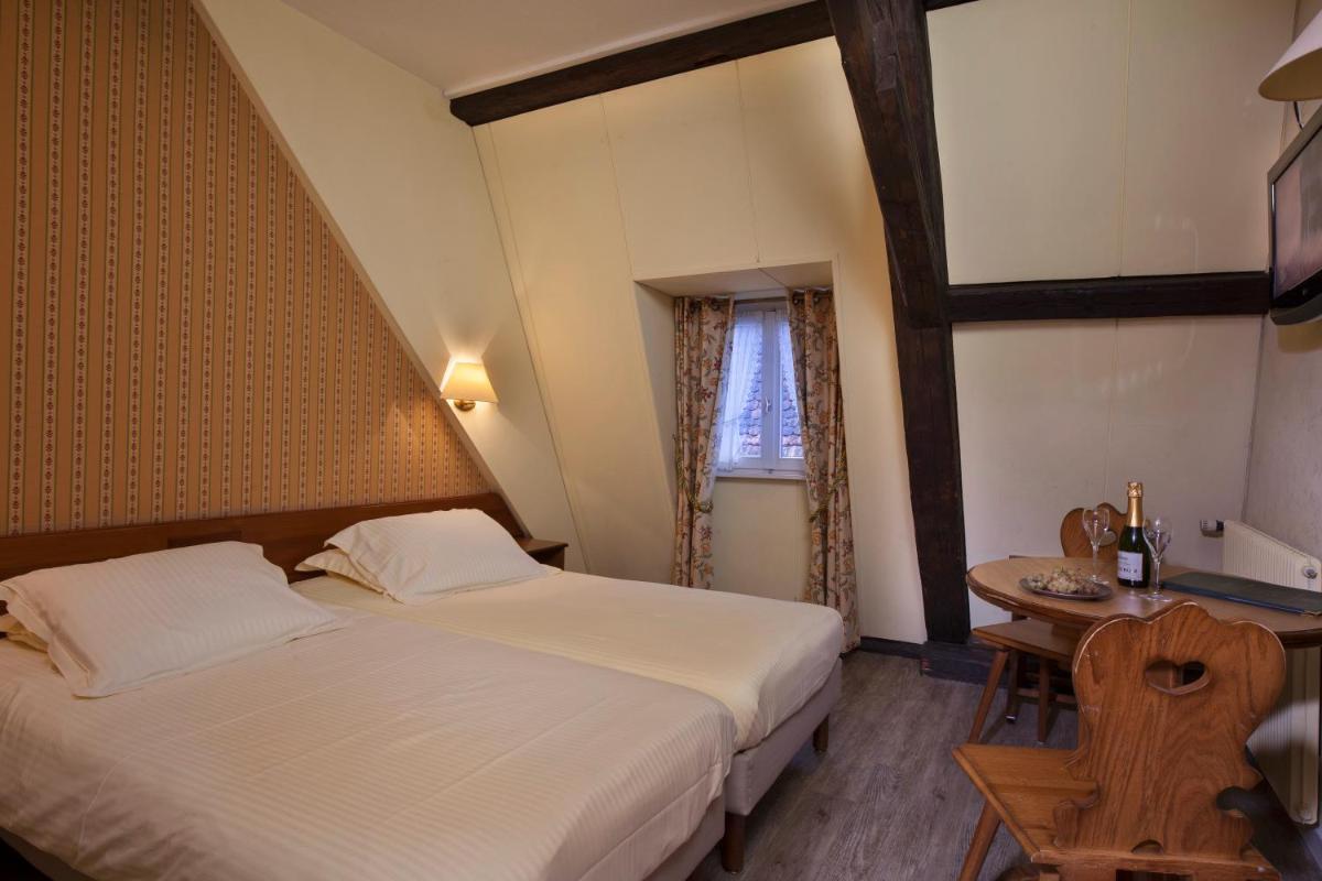 Un ou plusieurs lits dans un hébergement de l'établissement Logis Hôtel de la Tour