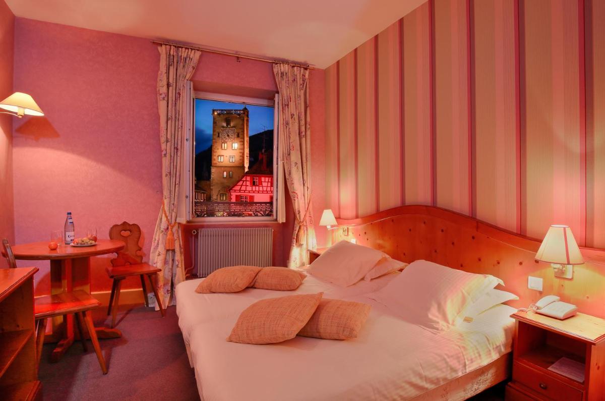 Un ou plusieurs lits dans un hébergement de l'établissement Logis Hôtel de la Tour