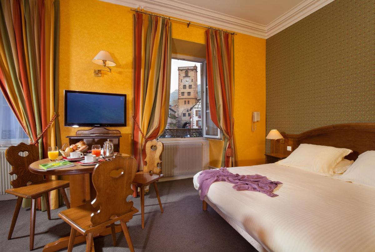 Un ou plusieurs lits dans un hébergement de l'établissement Logis Hôtel de la Tour