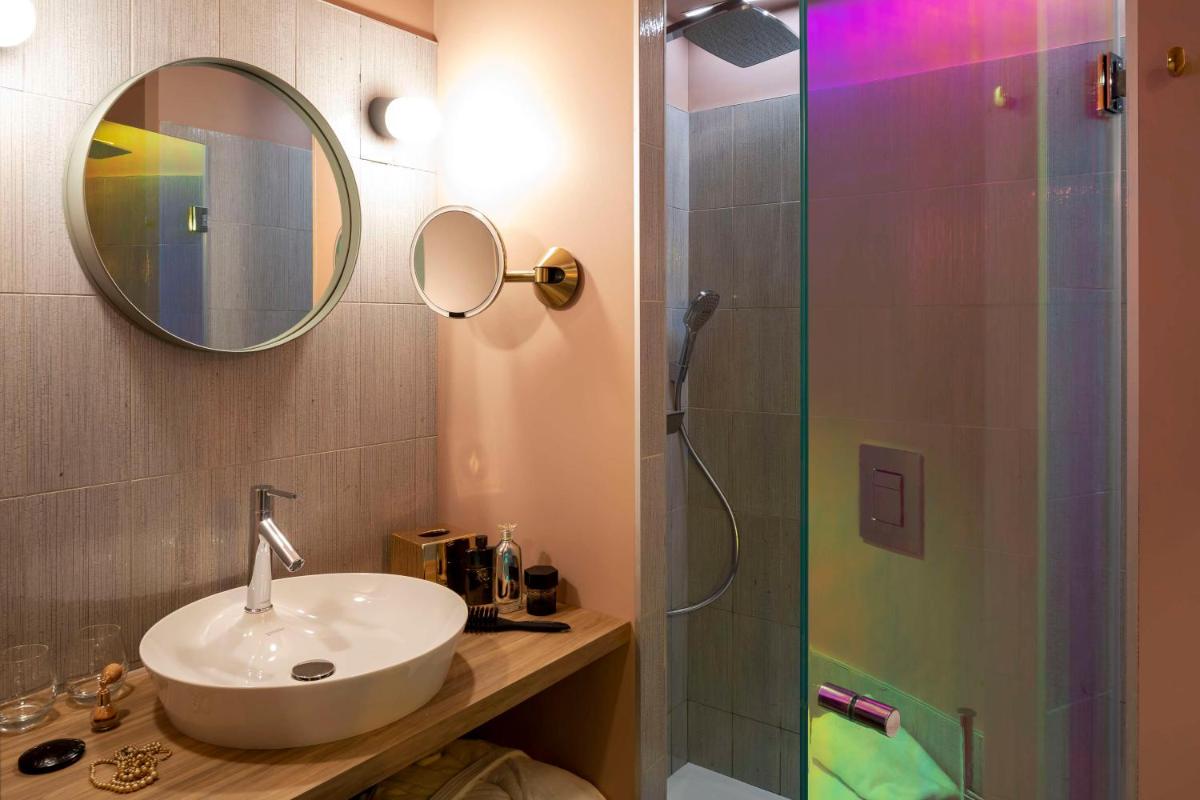 une salle de bains avec lavabo et douche avec miroir dans l'établissement Aiden by Best Western Clermont-Ferrand Hotel & Spa, à Clermont-Ferrand