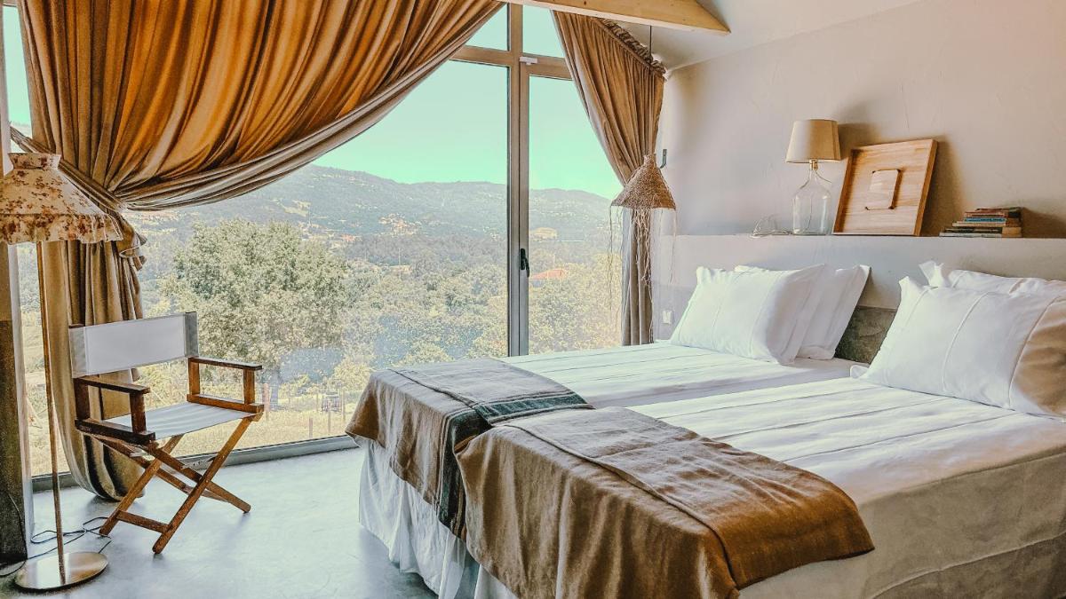 um quarto com uma cama e uma janela grande em Carmo's Boutique Hotel - Small Luxury Hotels of the World em Ponte de Lima