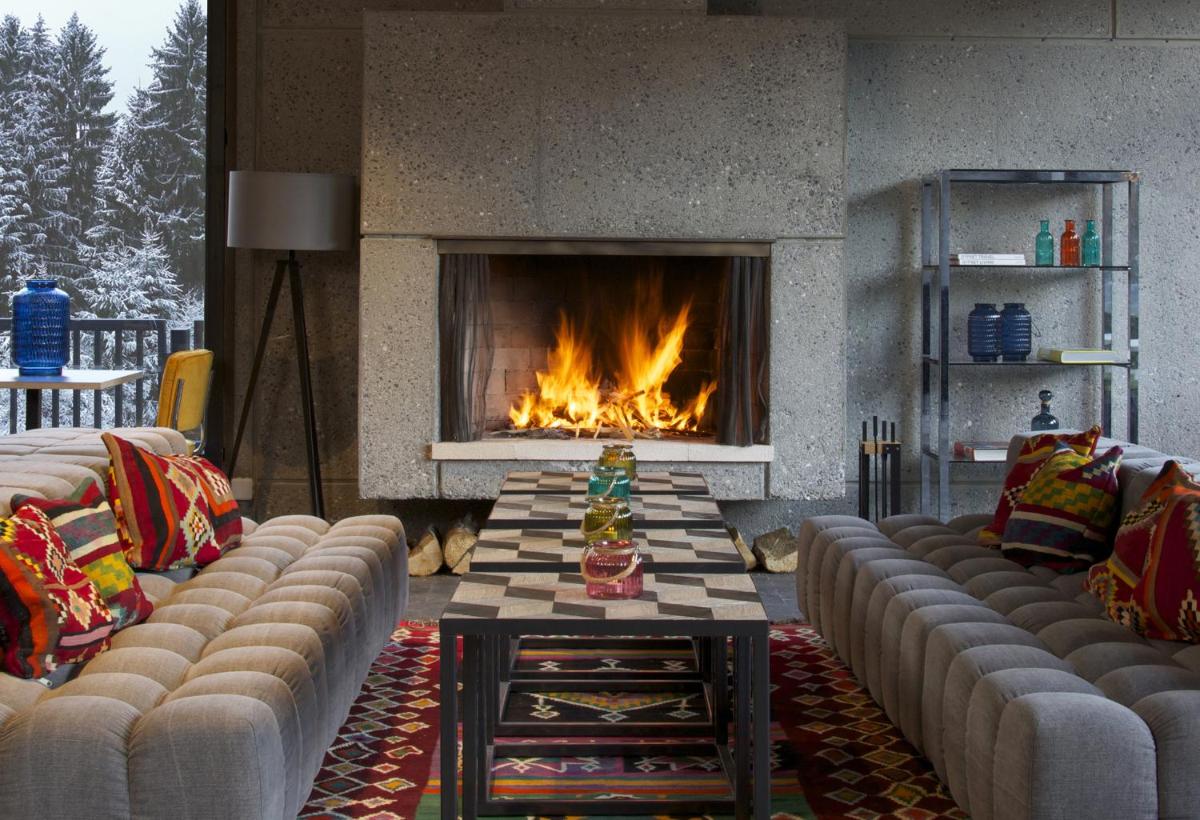 un salon avec des canapés et une cheminée dans l'établissement Totem, Friendly Hotel & Spa, à Flaine