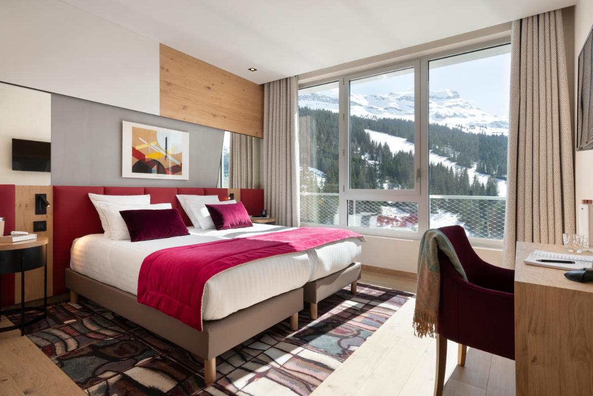 une chambre avec un lit et une grande fenêtre dans l'établissement MGM Hôtels & Résidences - Hôtel Alhéna, à Flaine