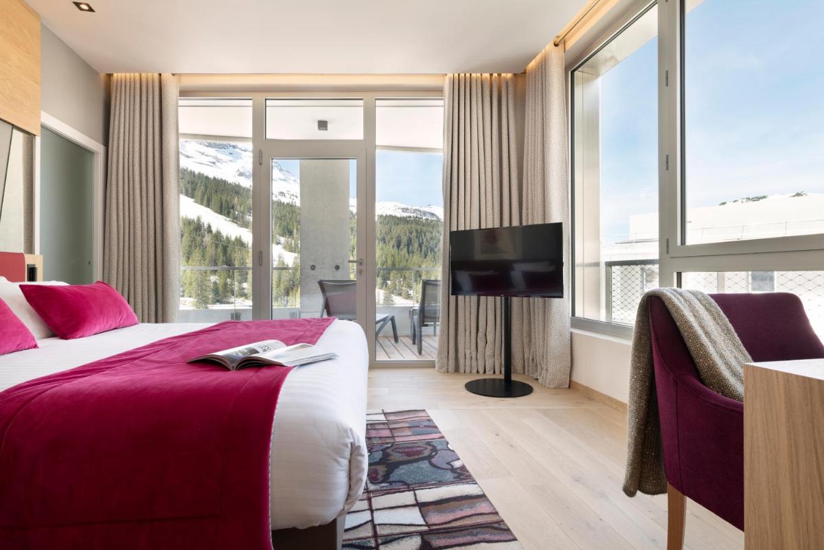 une chambre d'hôtel avec un lit et une grande fenêtre dans l'établissement MGM Hôtels & Résidences - Hôtel Alhéna, à Flaine
