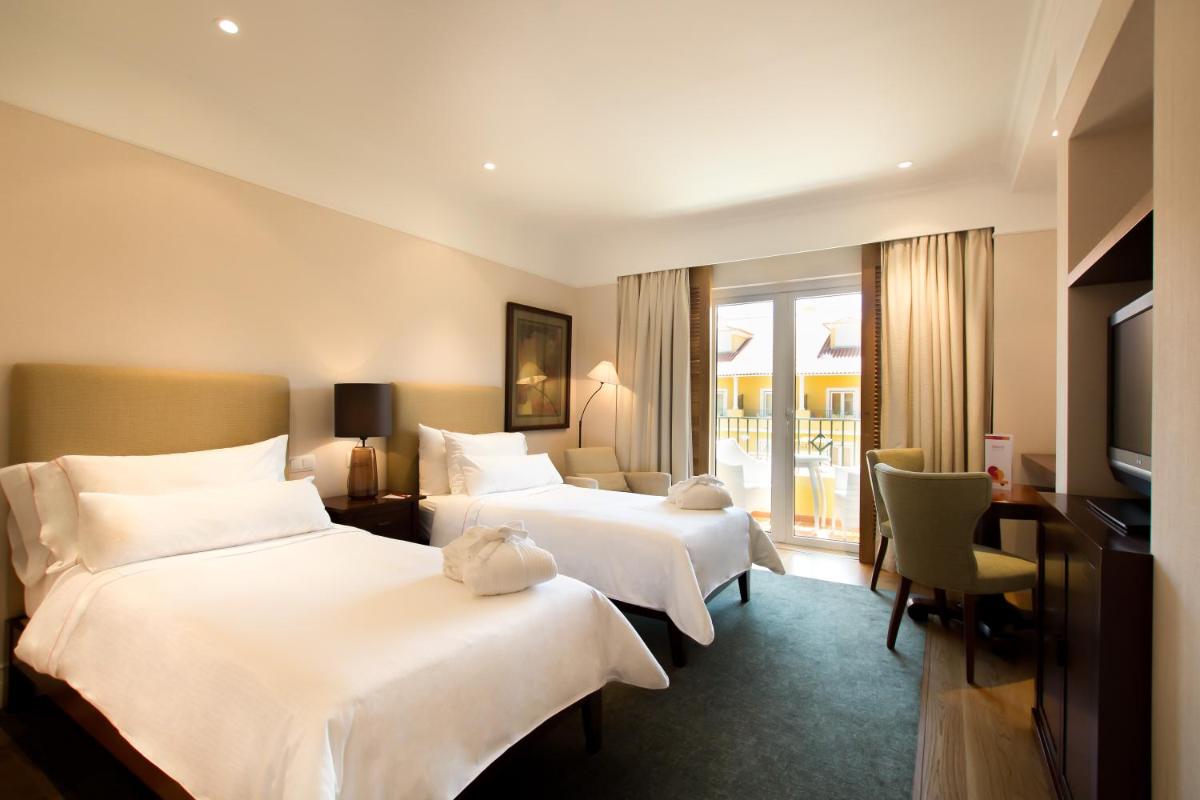 Uma cama ou camas num quarto em Dolce CampoReal Lisboa