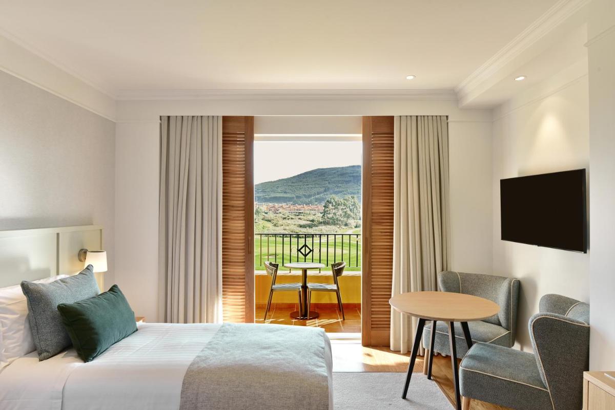 Uma cama ou camas num quarto em Dolce CampoReal Lisboa
