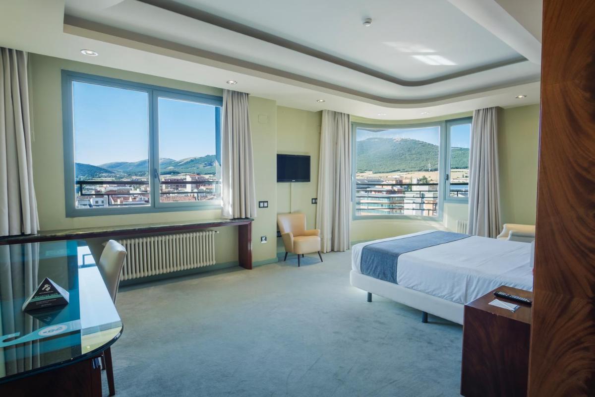 Una habitación de hotel con una cama y grandes ventanales. en Alda Mirador del Moncayo, en Ólvega 110 fotos más