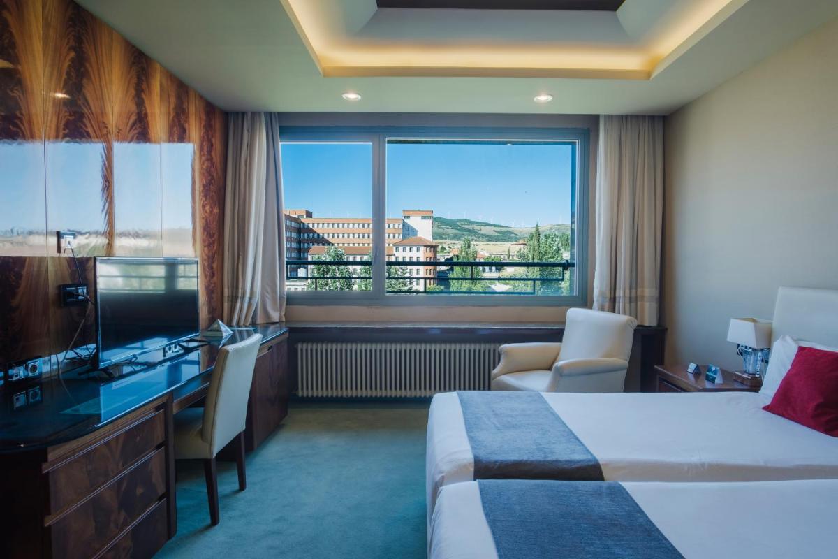 Una habitación de hotel con una cama y una ventana grande. en Alda Mirador del Moncayo, en Ólvega