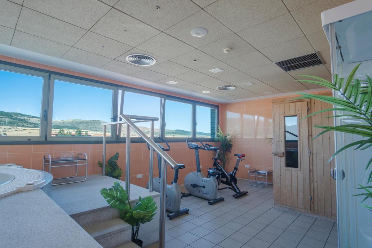 un gimnasio con máquinas de ejercicio en una sala con ventanas en Alda Mirador del Moncayo, en Ólvega