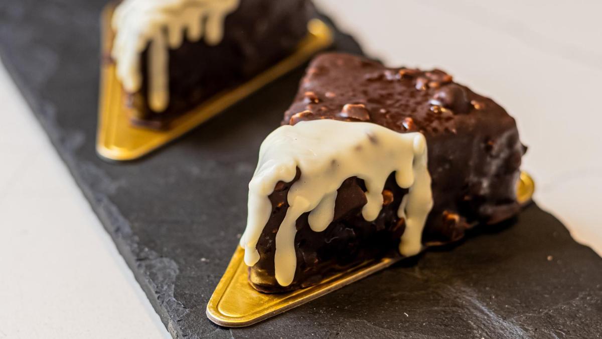 a chocolate dessert with white icing on a gold plate at Crowne Plaza Today Gurugram by IHG in Gurgaon