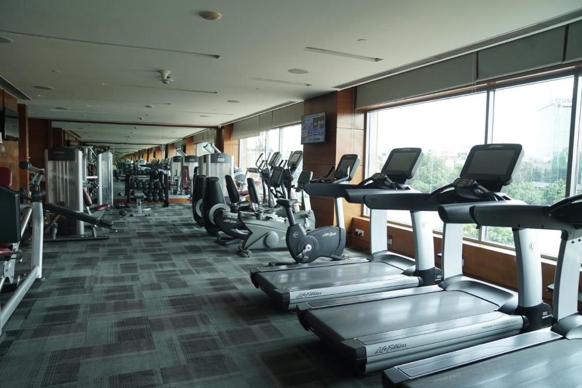 a gym with a row of treadmills and machines at Crowne Plaza Today Gurugram by IHG in Gurgaon