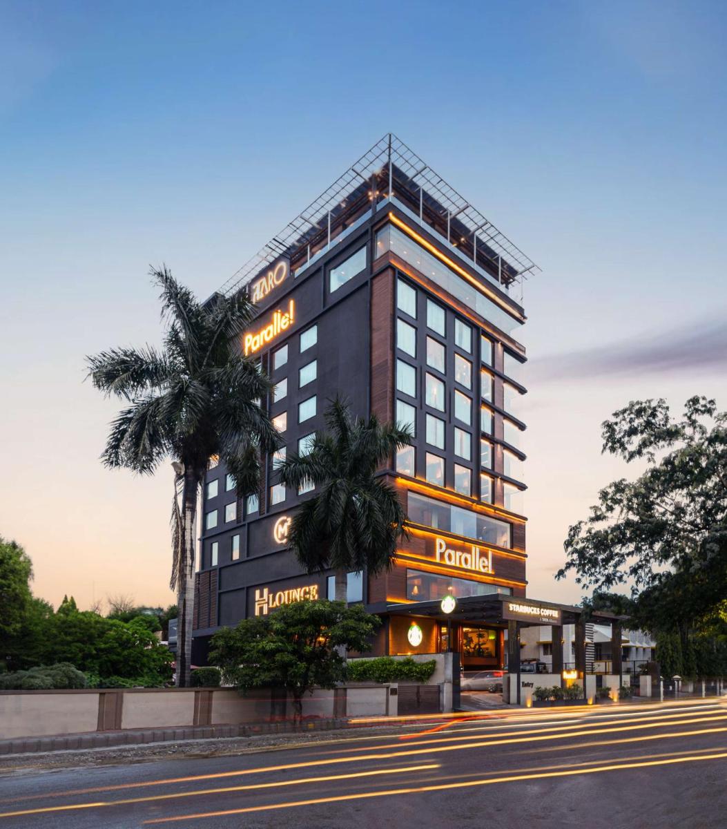 a hotel building with a palm tree in front of it at Parallel Hotel Udaipur, a member of Radisson Individuals in Udaipur