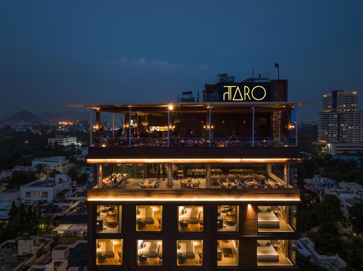 a building with a restaurant on top of it at night at Parallel Hotel Udaipur, a member of Radisson Individuals in Udaipur