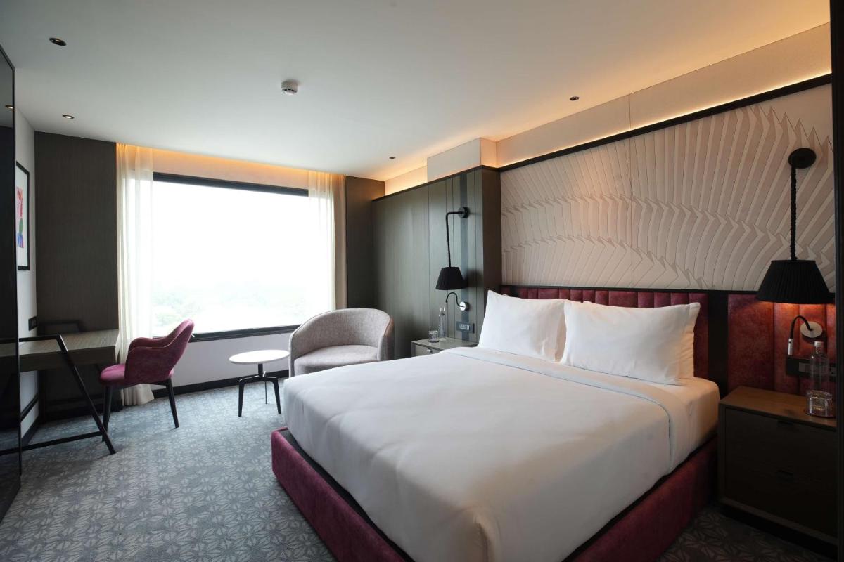 a hotel room with a large bed and a desk at Parallel Hotel Udaipur, a member of Radisson Individuals in Udaipur