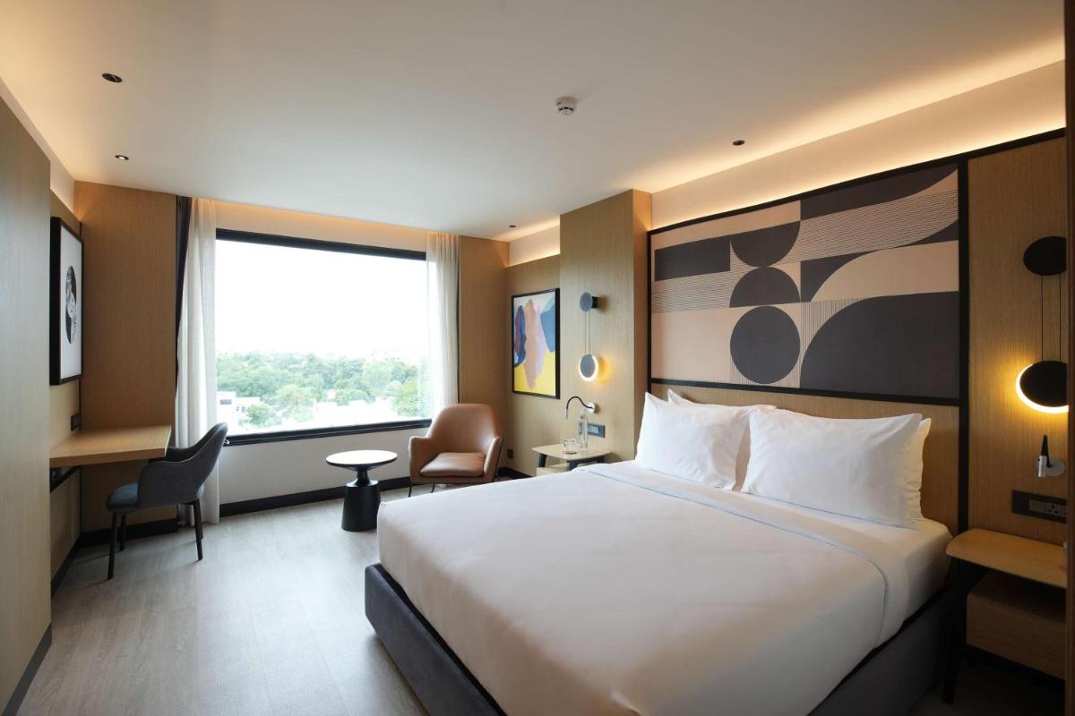 a hotel room with a large bed and a window at Parallel Hotel Udaipur, a member of Radisson Individuals in Udaipur