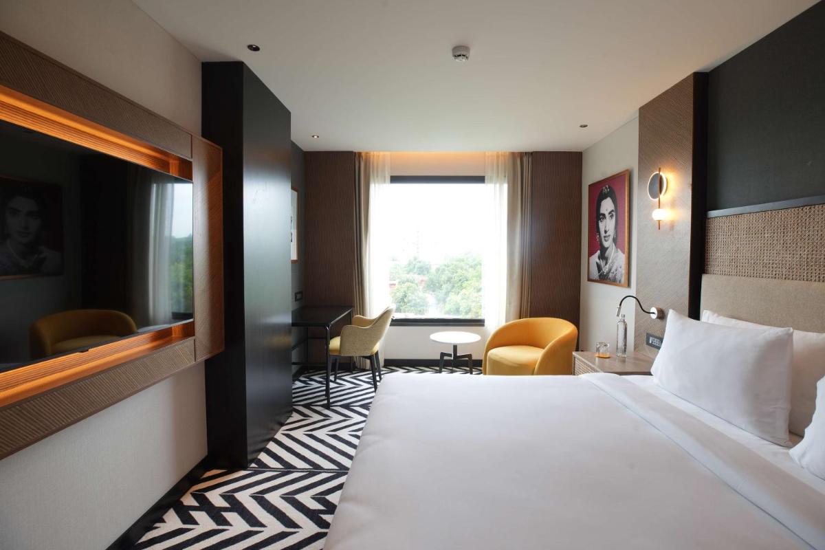 a hotel room with a large bed and a desk at Parallel Hotel Udaipur, a member of Radisson Individuals in Udaipur