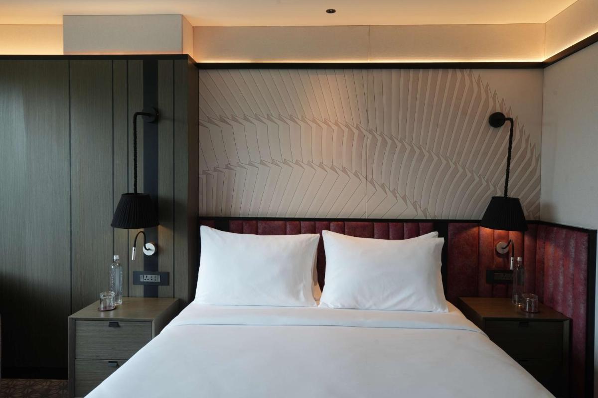 a bedroom with a large bed with two white pillows at Parallel Hotel Udaipur, a member of Radisson Individuals in Udaipur