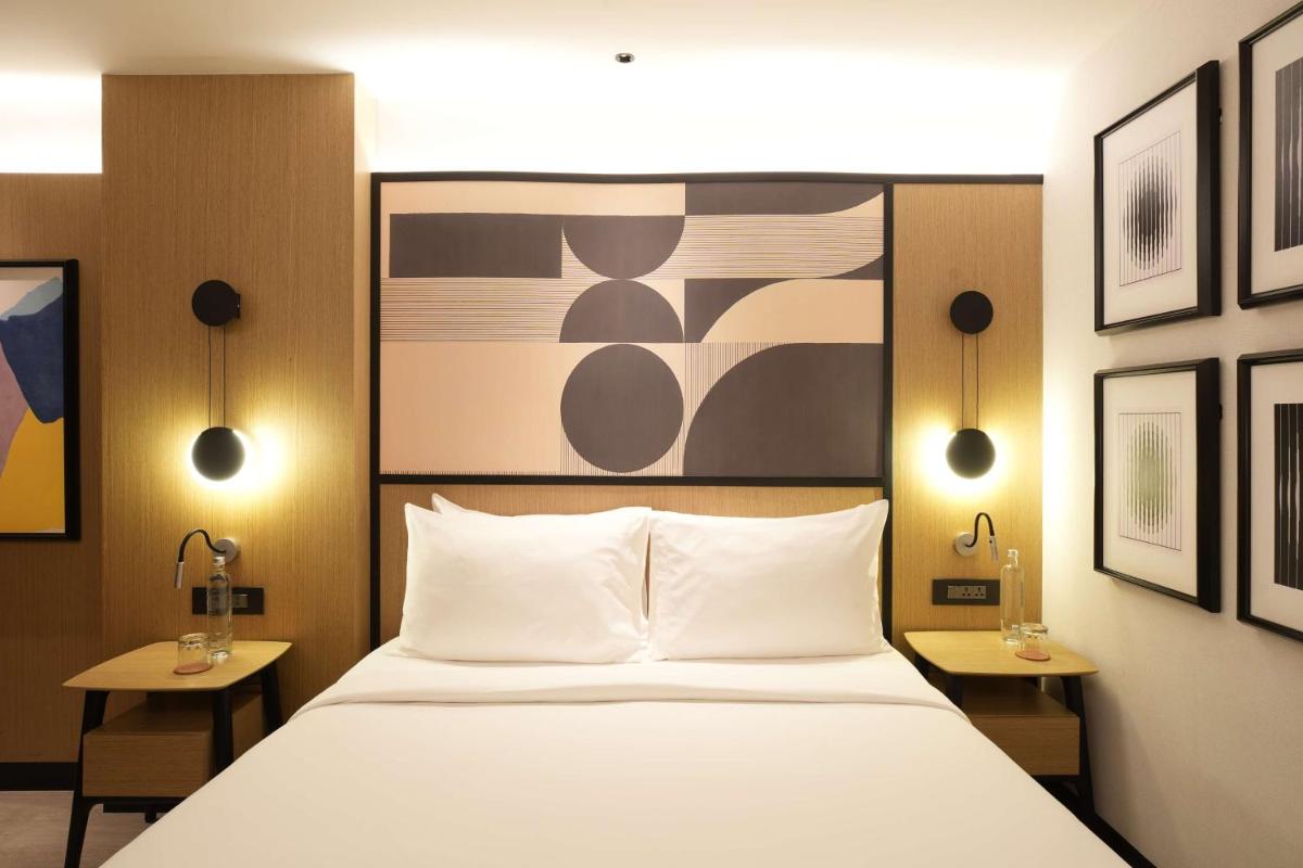 a bedroom with a large bed with two tables and two lamps at Parallel Hotel Udaipur, a member of Radisson Individuals in Udaipur