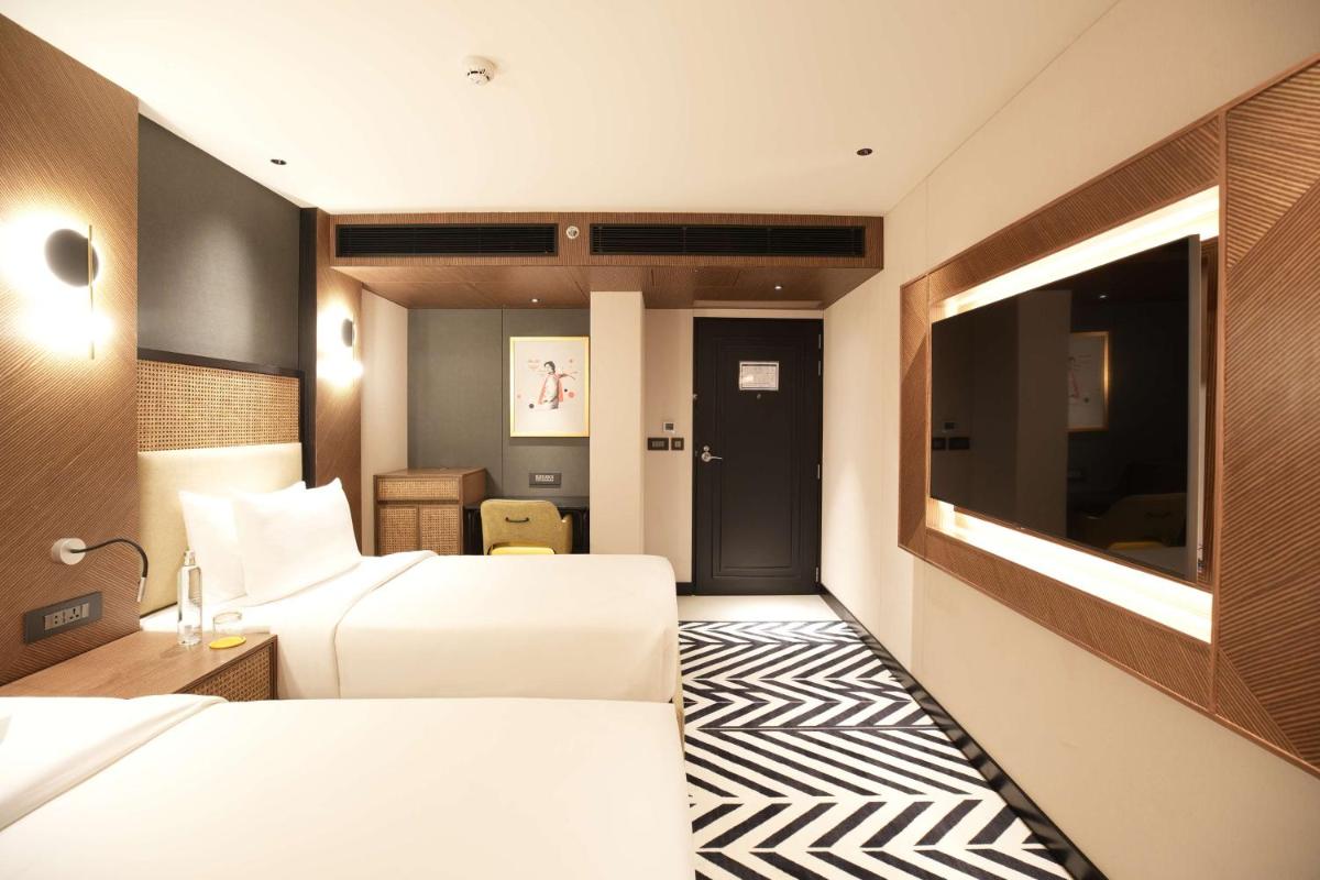 a hotel room with two beds and a television at Parallel Hotel Udaipur, a member of Radisson Individuals in Udaipur