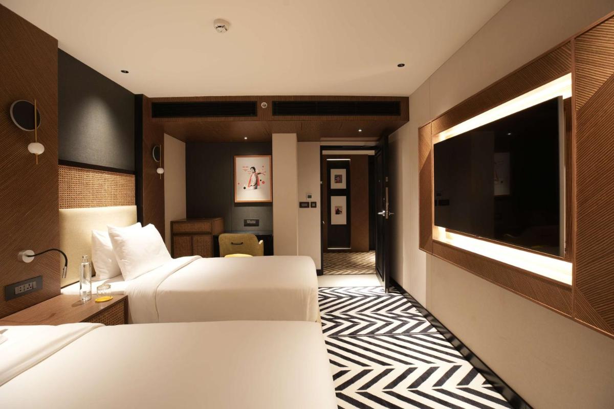 a hotel room with two beds and a flat screen tv at Parallel Hotel Udaipur, a member of Radisson Individuals in Udaipur