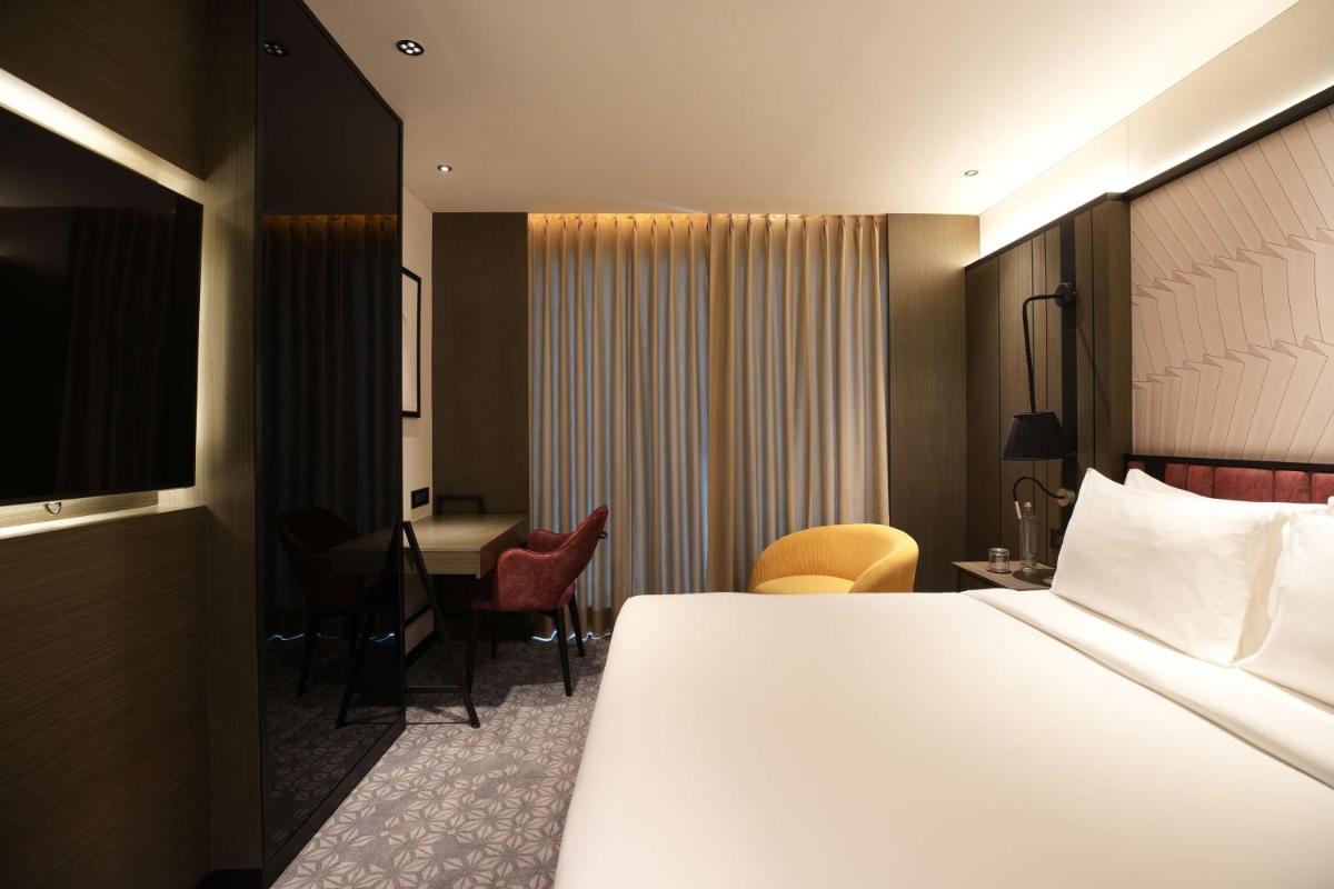 a hotel room with a large bed and a desk at Parallel Hotel Udaipur, a member of Radisson Individuals in Udaipur