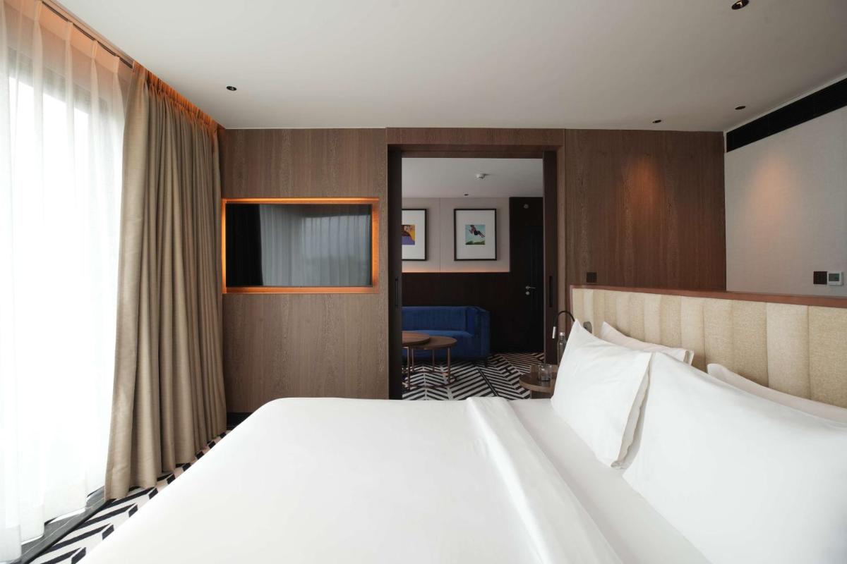 a hotel room with a large bed and a television at Parallel Hotel Udaipur, a member of Radisson Individuals in Udaipur