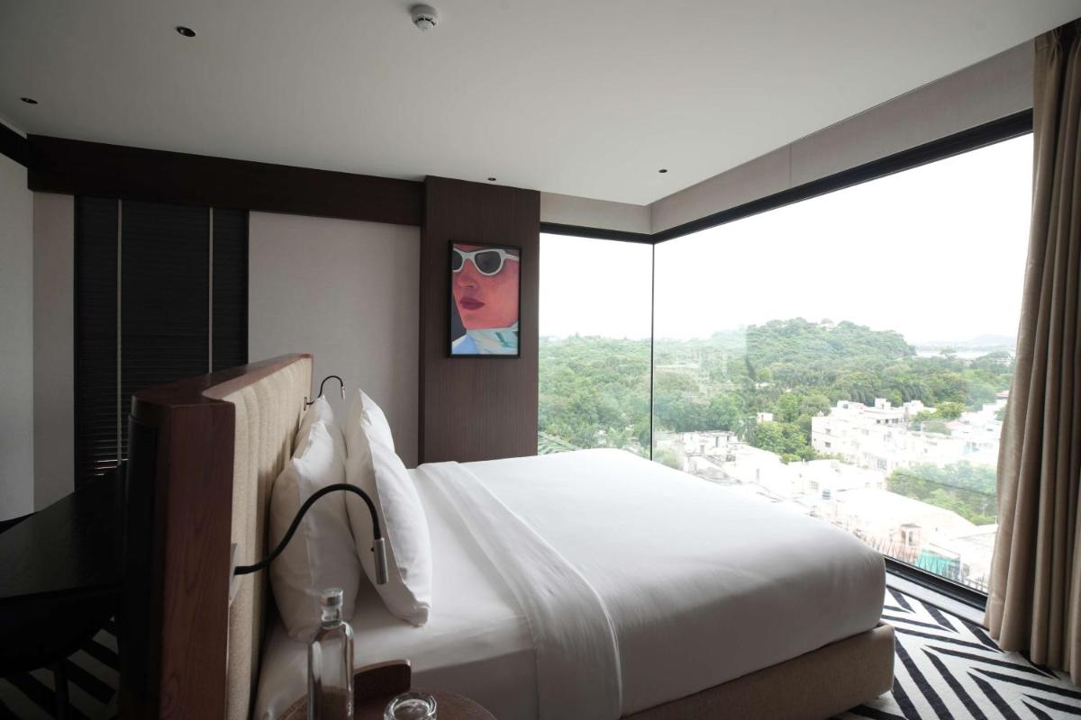 a bedroom with a bed and a large window at Parallel Hotel Udaipur, a member of Radisson Individuals in Udaipur
