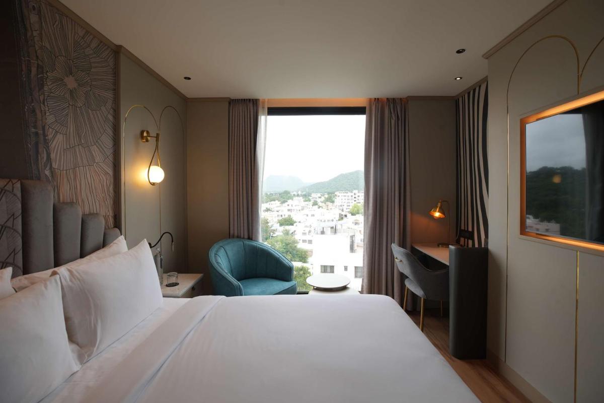 a hotel room with a large bed and a window at Parallel Hotel Udaipur, a member of Radisson Individuals in Udaipur