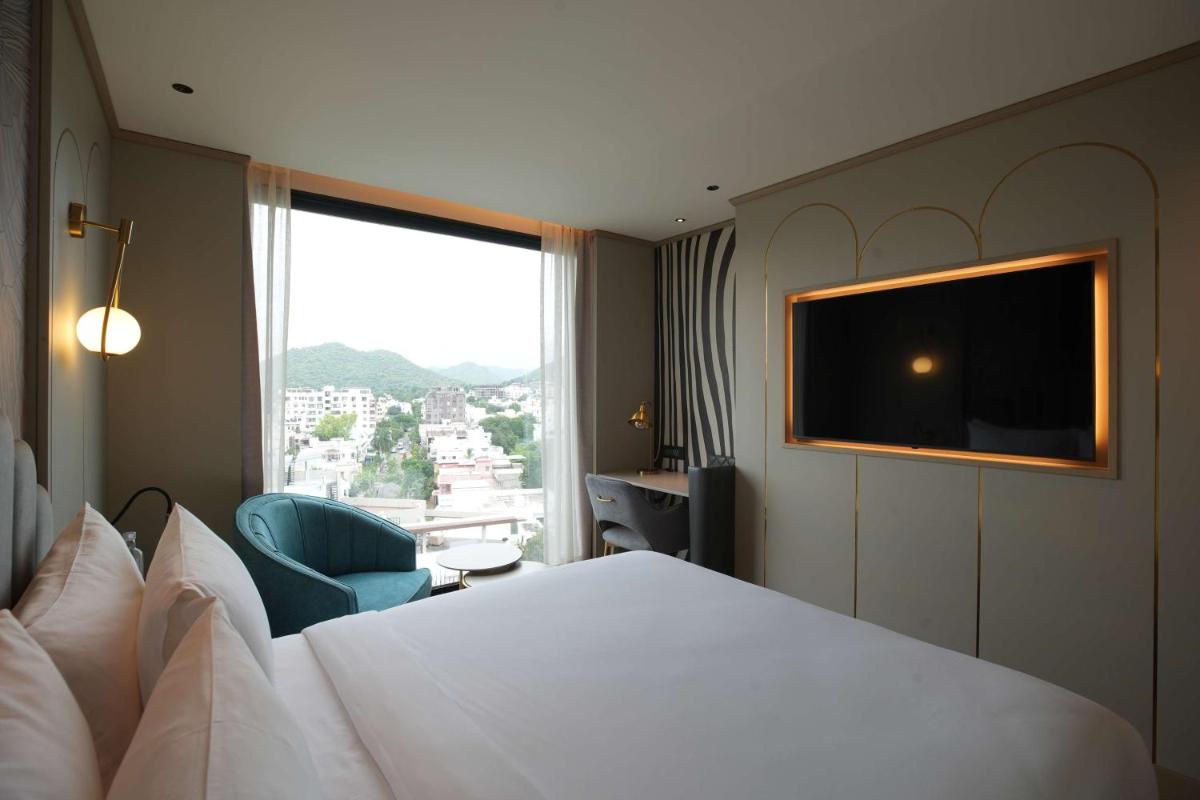 a hotel room with a bed and a large window at Parallel Hotel Udaipur, a member of Radisson Individuals in Udaipur