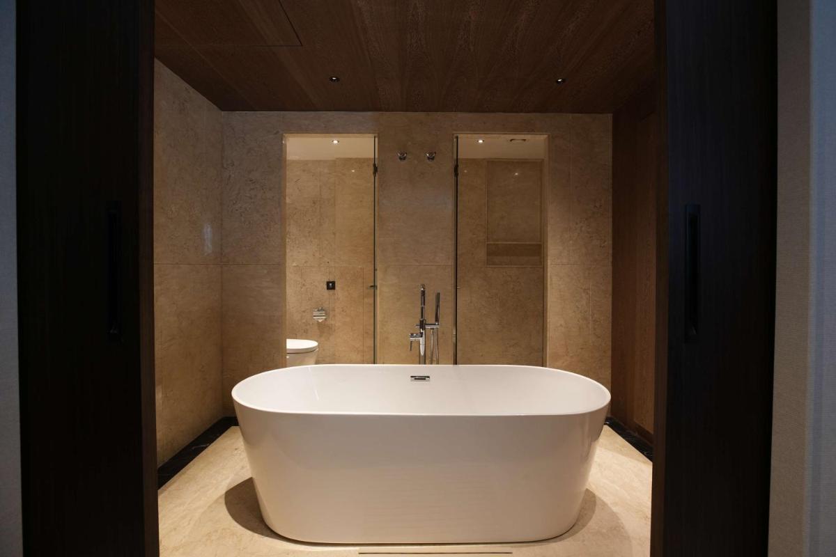 a large white tub in a bathroom with a shower at Parallel Hotel Udaipur, a member of Radisson Individuals in Udaipur