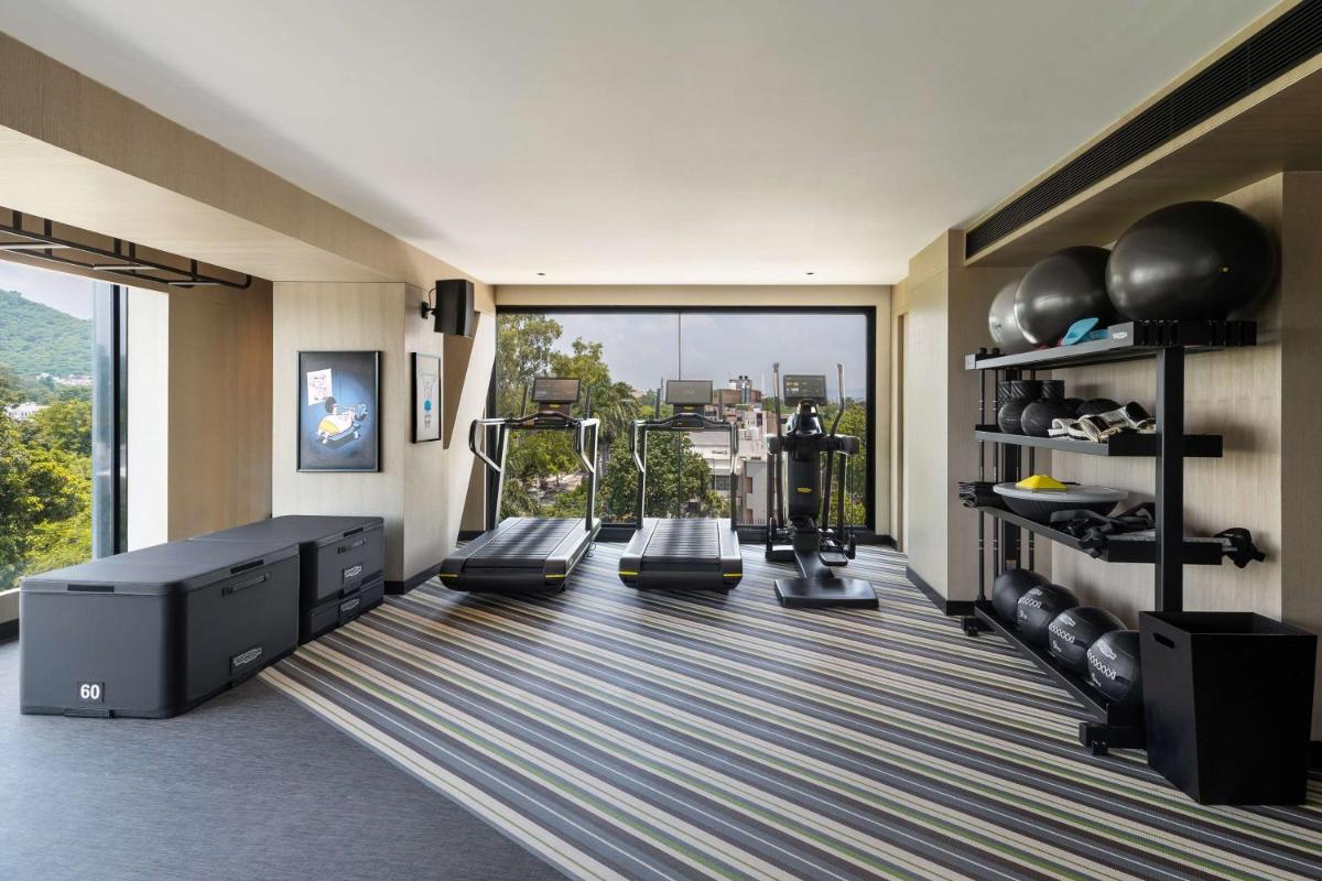 a fitness room with a gym with a large window at Parallel Hotel Udaipur, a member of Radisson Individuals in Udaipur