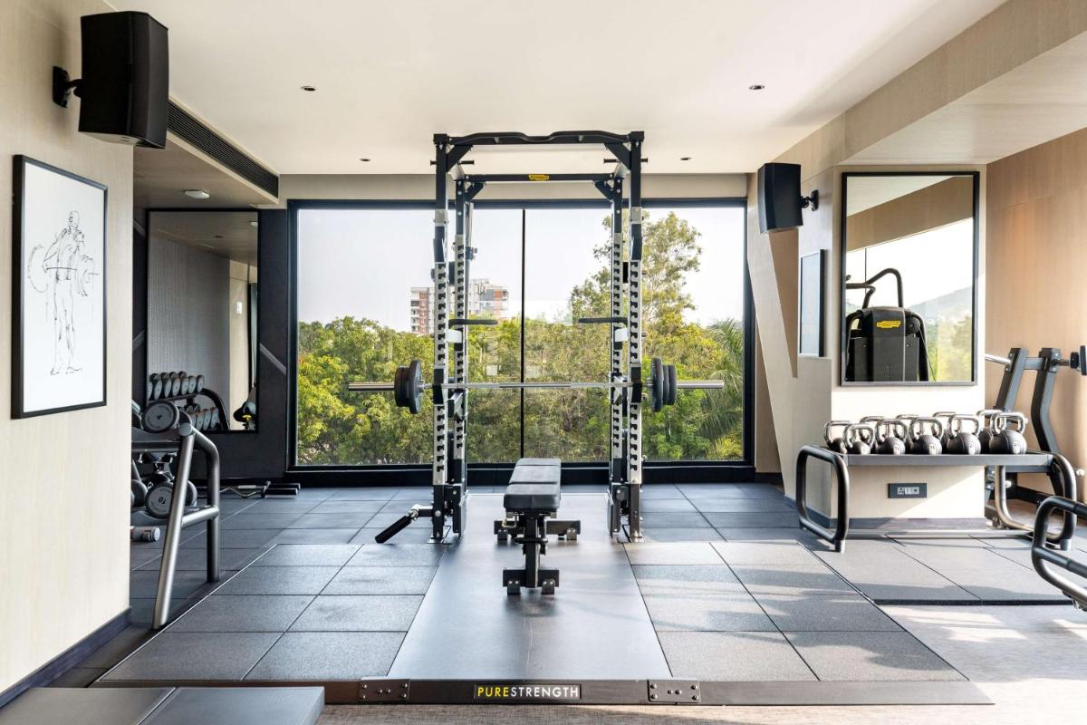 a gym with a lot of equipment and a large window at Parallel Hotel Udaipur, a member of Radisson Individuals in Udaipur