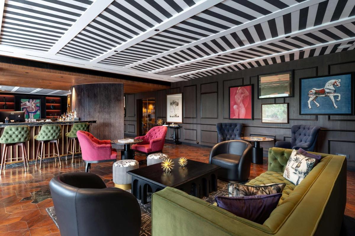 a lobby with chairs and tables and a bar at Parallel Hotel Udaipur, a member of Radisson Individuals in Udaipur