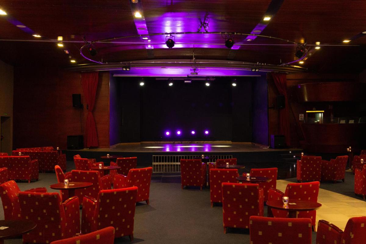 Un teatro vacío con sillas rojas y un escenario. en R2 Hotel Pajara Beach, en Costa Calma 16 fotos más