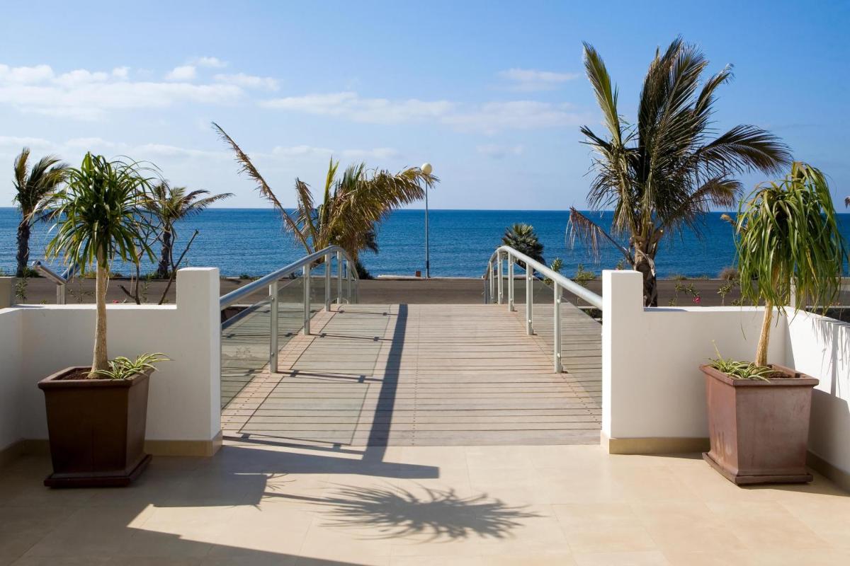 una escalera que conduce a la playa con palmeras en R2 Bahia Playa - Adults Only, en Tarajalejo