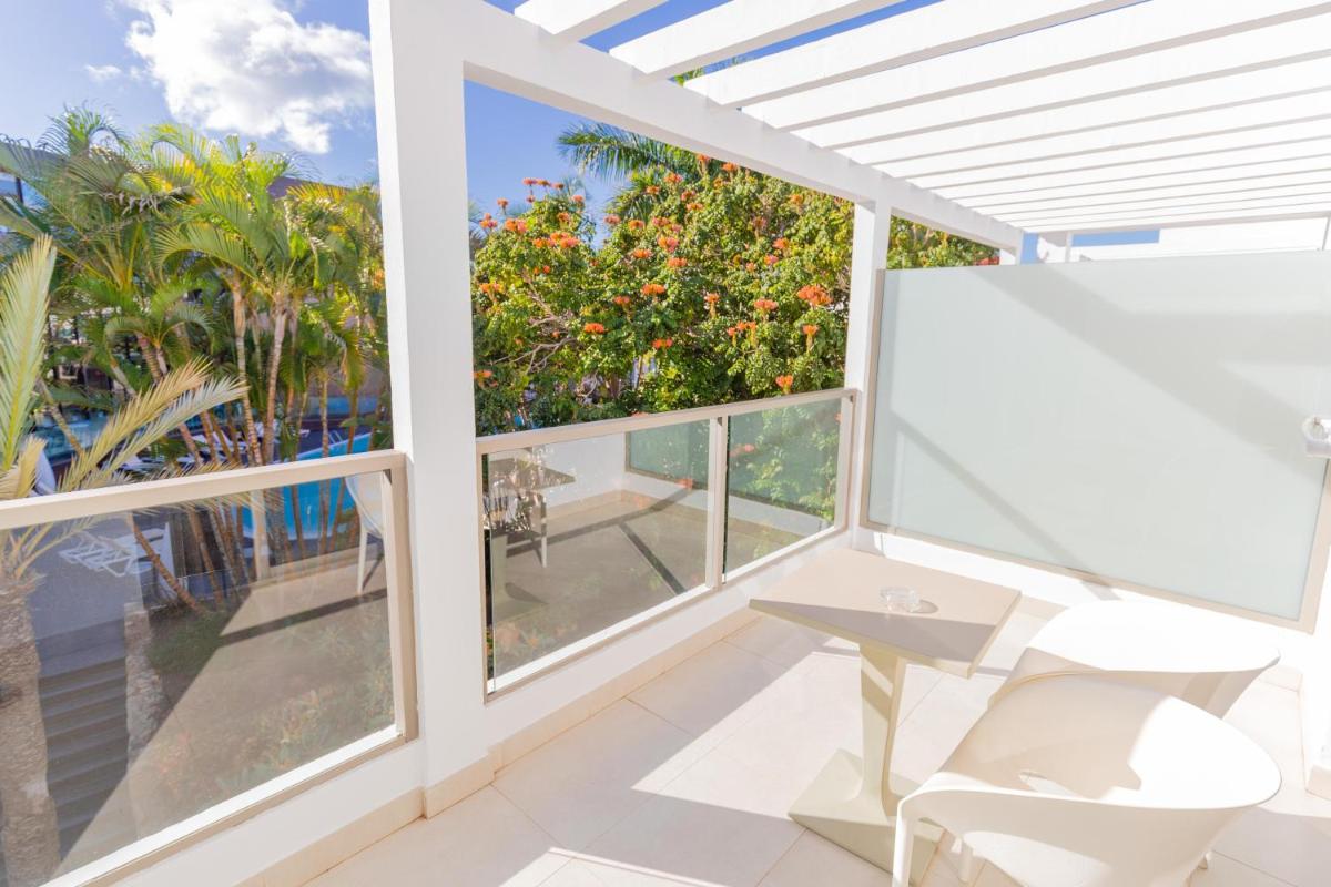 Un balcón con mesa y vista al mar. en R2 Bahia Playa - Adults Only, en Tarajalejo