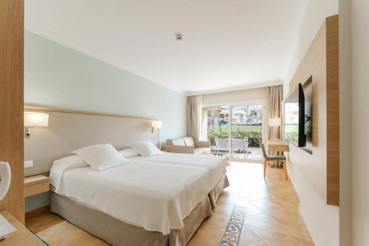 Un dormitorio con una cama grande y una sala de estar. en R2 Buganvilla Hotel & Spa, en Morro del Jable 29 fotos más