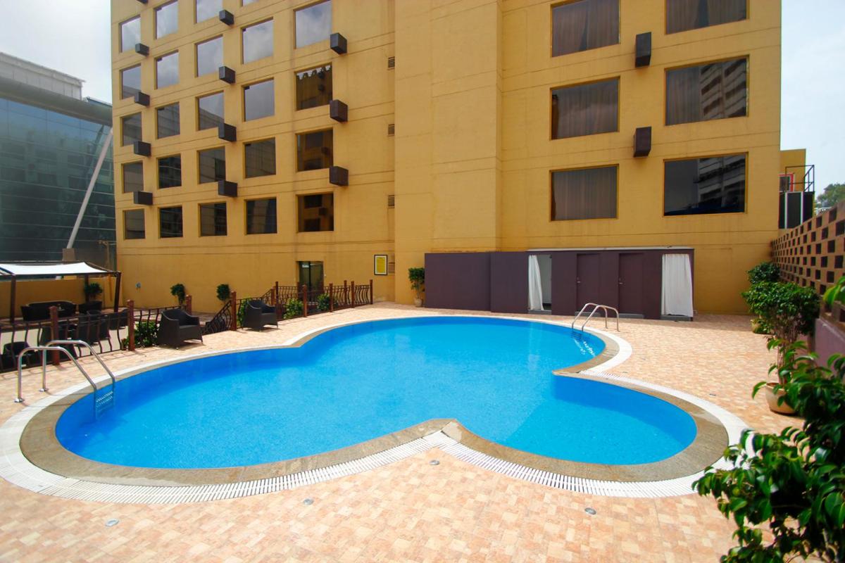 a large swimming pool in front of a building at Sterlings Mac Hotel in Bengaluru a large swimming pool in front of a building at Sterlings Mac Hotel in Bengaluru