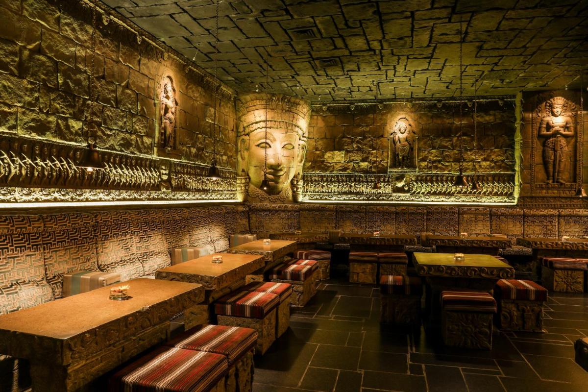 a restaurant with tables and portraits on the walls at Sterlings Mac Hotel in Bengaluru