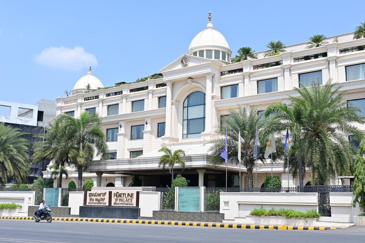 a man riding a motorcycle in front of a building at Fortune JP Palace, Mysore - Member ITC Hotels' Group in Mysore