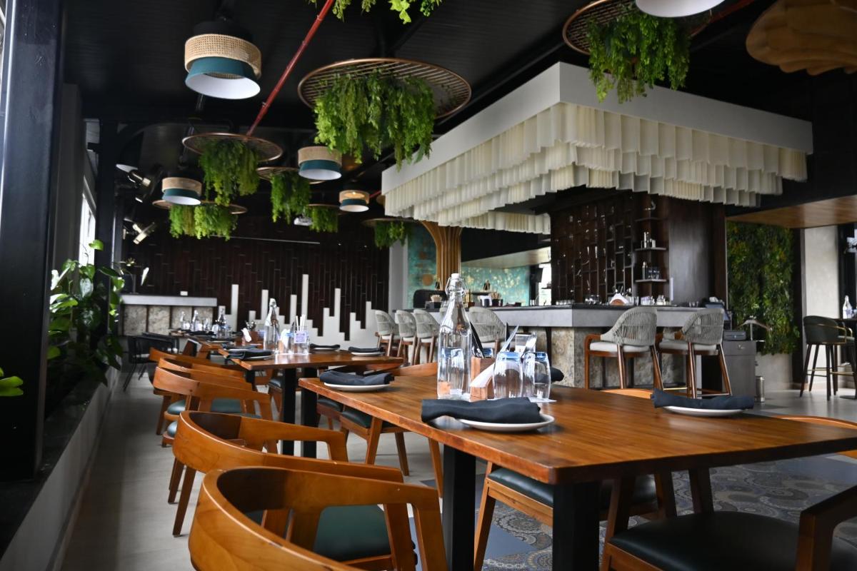 a restaurant with wooden tables and chairs at Fortune JP Palace, Mysore - Member ITC Hotels' Group in Mysore