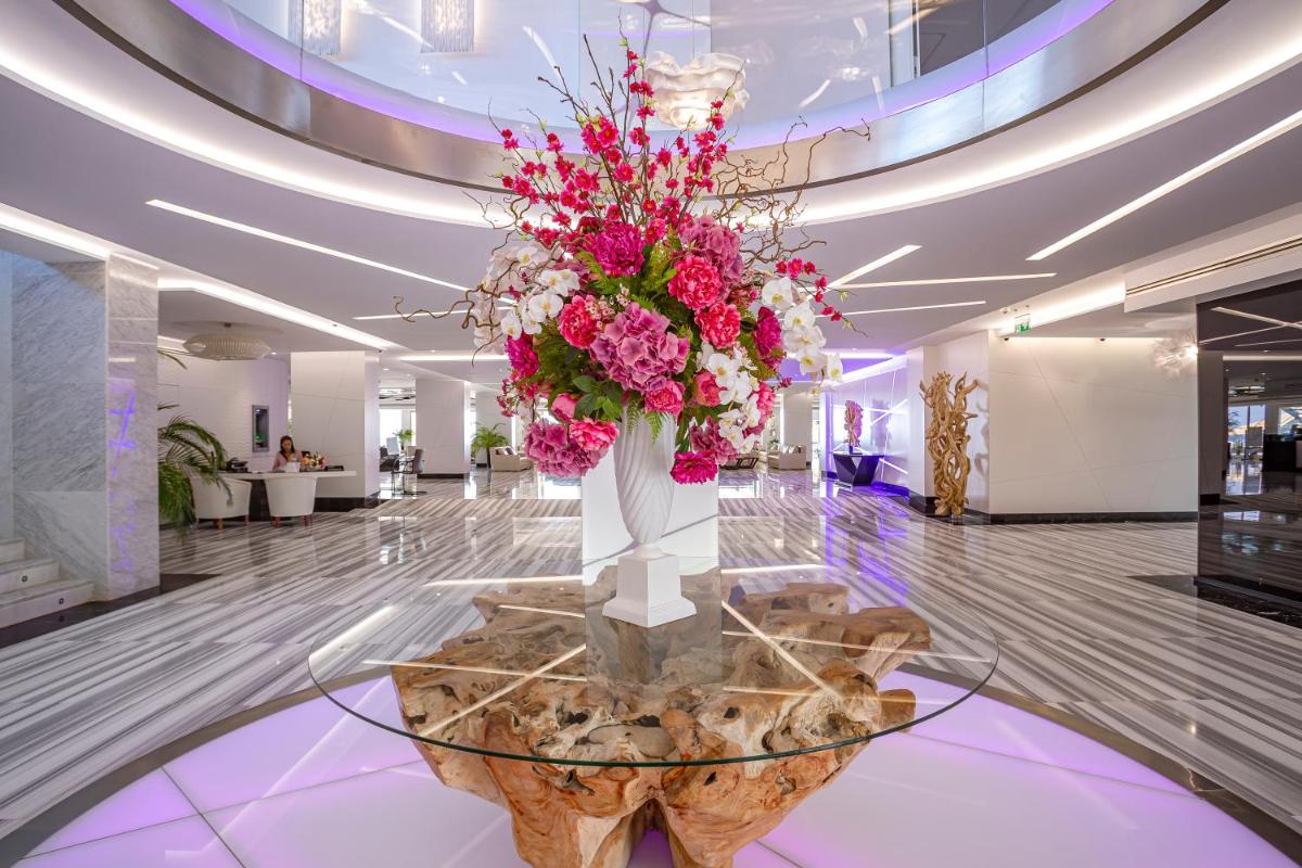 Un gran jarrón de flores sobre una mesa en un vestíbulo. en Hotel Torre del Mar - Ibiza, en Playa d'en Bossa
