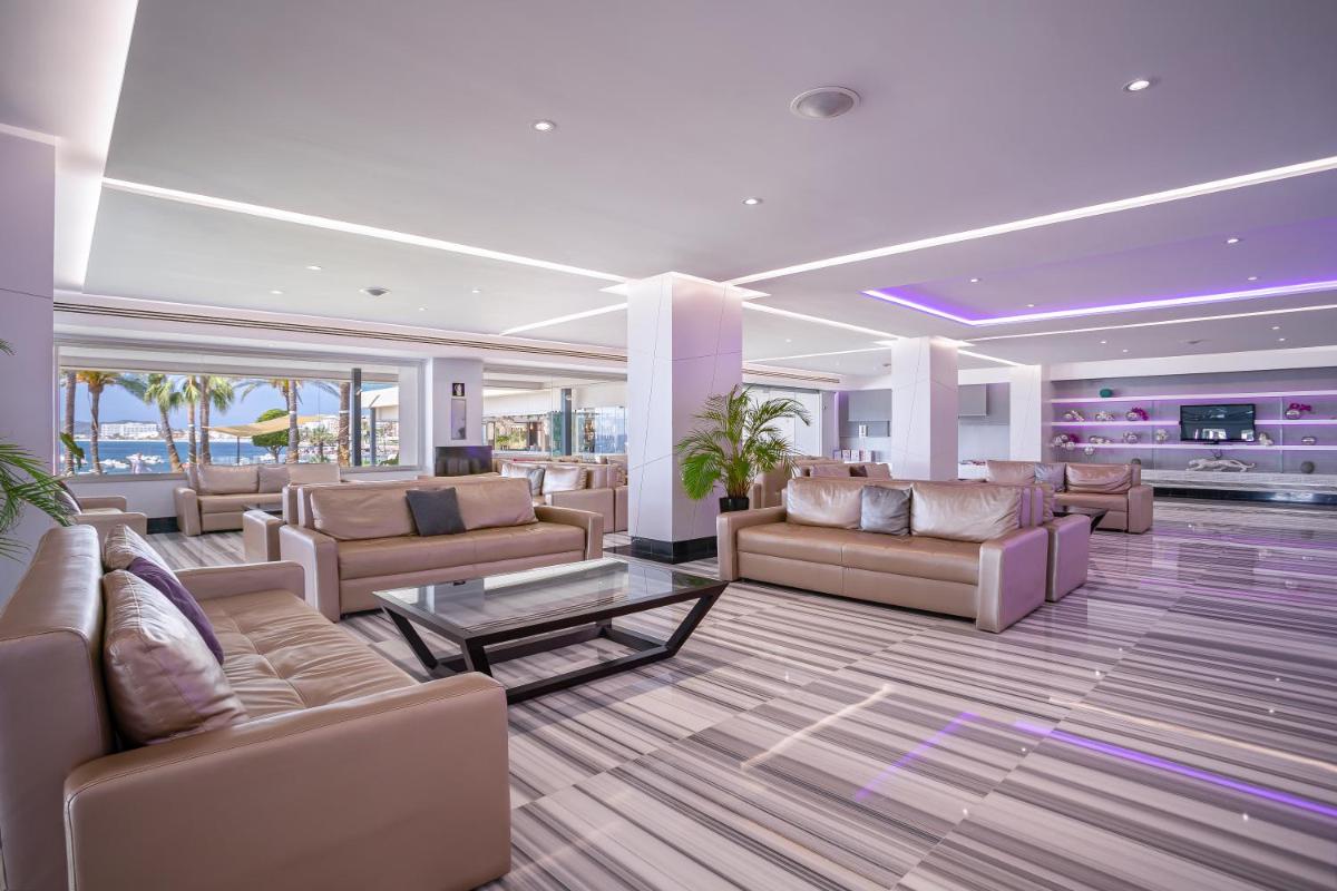 Una gran sala de estar con sofás y una mesa. en Hotel Torre del Mar - Ibiza, en Playa d'en Bossa